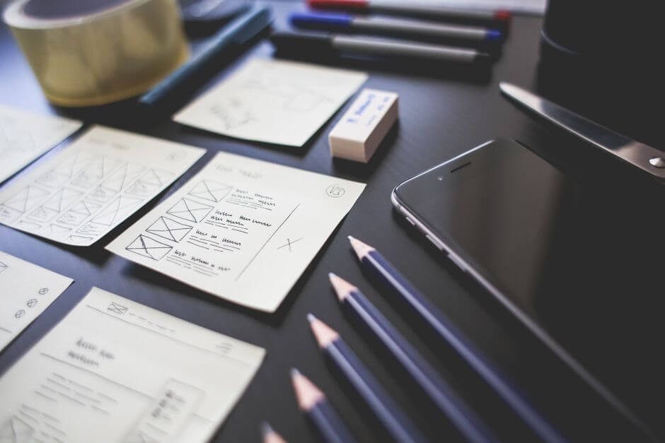 graphic design to ux design designer sketching wireframes over colorful graphic layout
