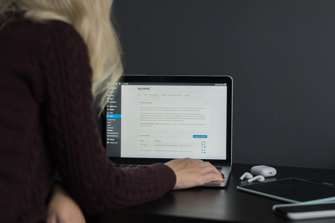 A professional copywriter drafting website content on a modern laptop